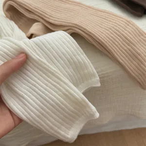 Close-up of ribbed knit long socks, soft cotton fabric texture, cozy autumn winter hosiery.