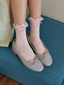 Close-up detail of sweet pink ruffle socks with cute polka dots and bow, comfortable fit.