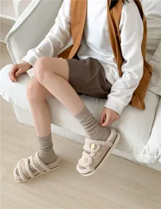 Detail shot of women's ribbed knit slouchy crew socks worn with comfortable cozy plush shoes.