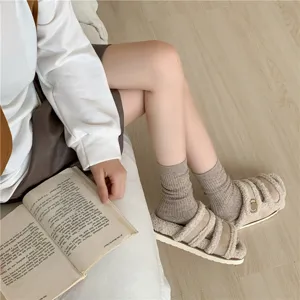 Detailed shot of ribbed wool slouch socks in soft beige, cozy winter knitwear texture.