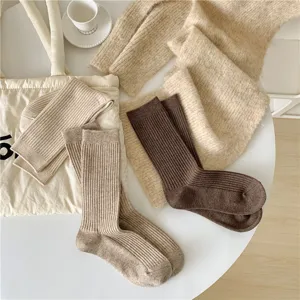 Close up view of ribbed knit vintage wool socks detail displayed on a clean white table.