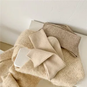 Close-up detail of vertical striped knit wool slouch socks in soft beige cozy style.