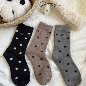 Detailed view of women winter warm wool socks featuring cute polka dots and bow embroidery design.