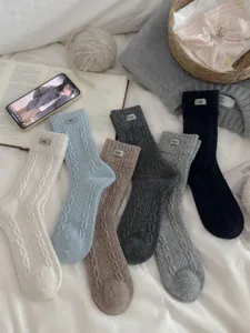 Thick wool knit mid-tube socks with brand label, warm winter cozy fashion hosiery styles.