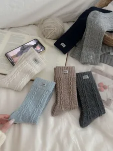 Knitted wool blend winter mid-calf socks with cute label detail, cozy casual style.