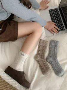 Close-up detail shot of cozy thick rabbit wool mid-tube socks featuring cute cloth labels.