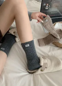 Close-up of cozy thick warm winter socks with a cloth label tag, soft fabric detail shot.