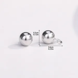 Gros plan de charms perles rondes en argent avec cotes, idéal pour la fabrication de bijoux.