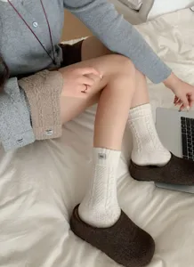 Close-up of thick cable-knit cozy warm socks with small label detail, perfect autumn winter wear.