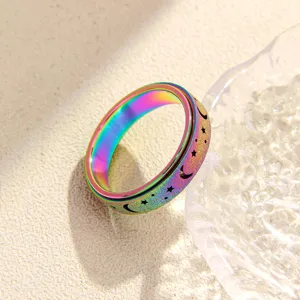 Primo piano dettagliato dell'anello arcobaleno in acciaio con motivi di stelle e luna opachi.