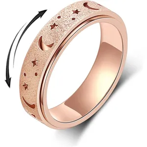 Dettaglio anello antistress in acciaio, finitura oro rosa opaco, stelle e luna intagliate.