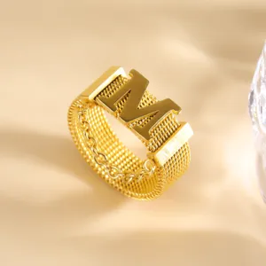 Gouden mesh geweven letter M ring detailopname, elegante roestvrijstalen mode vinger sieraden