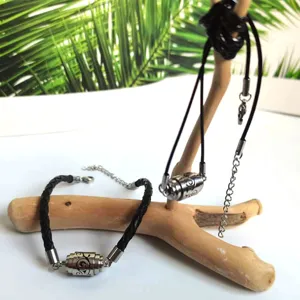Close-up van roestvrijstalen diffuser armband en halsketting set met uitgesneden motief.