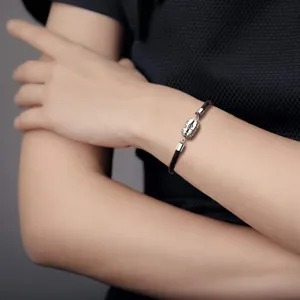 Detail van roestvrijstalen diffuser armband met zwart koord en holle hanger.