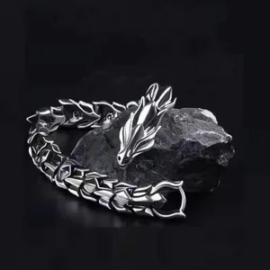 Gros plan d'un bracelet dragon punk vintage écaille et os, finition argentée détaillée métal.