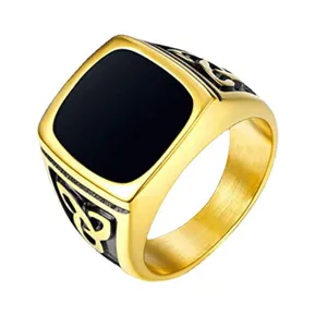 Detail view of men gold stainless steel signet ring with black epoxy and Celtic knot pattern.