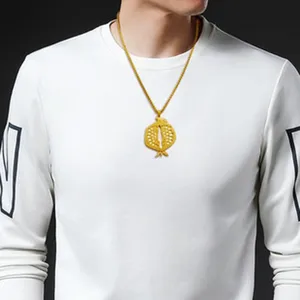 Gros plan détaillé du collier pendentif grenade évidé sculpté de couleur dorée sur le mannequin.