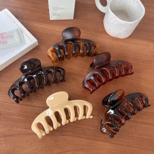 Large hollow hair claw clip for women, elegant tortoise shell shark clip for thick hair styling.