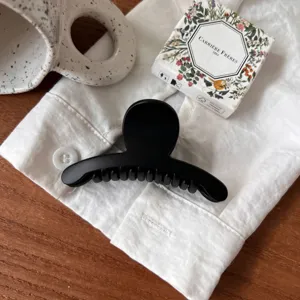 Gros plan d'une pince à cheveux noire minimaliste, style élégant de petite taille pour coiffure.