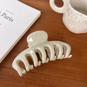 Minimalist large hair claw clip in light green resin, hollow keel design for daily hairstyles.