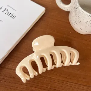 Detail view of a beige large hair claw clip, simple hollow design for daily styling.