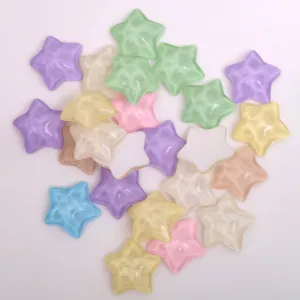 Détail de cabochons en résine en forme d'étoile ondulée translucide pour loisirs créatifs et pinces.