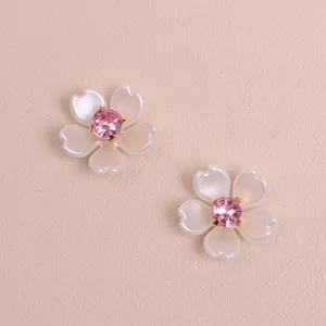 Close-up detail of exquisite DIY pearl five-petal flower with pink rhinestone center for crafts.