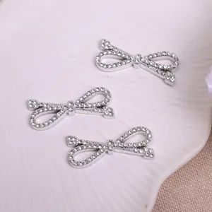 Gros plan détaillé de trois nœuds papillon strass brillants accessoires DIY argenté.