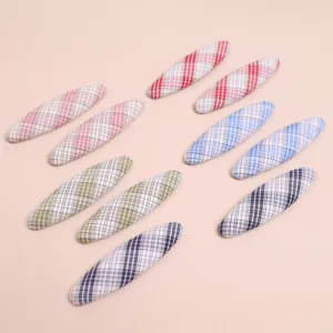Detailed shot of oval plaid fabric DIY hair clip patches and craft accessories, multi-color.