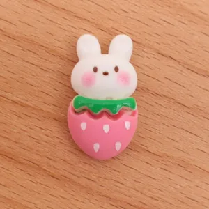 Detailed close-up view of cute cartoon rabbit strawberry resin DIY craft accessory.