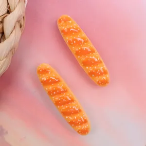 Close-up detail shot of miniature resin baguette bread charms for DIY crafts and accessories.
