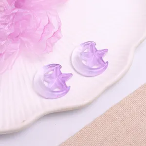 Detailed shot of purple translucent star and moon resin DIY hair clips and craft patches.