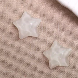 Gros plan de cabochons en résine en forme d'étoile ondulée translucide, texture fine pour bricolage.