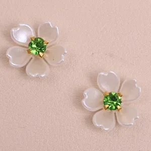 Detail shot of DIY five petal flower patch with white pearl petals and green rhinestone center.
