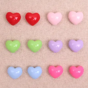 Detailed close-up of colorful resin heart cabochons, glossy finish for DIY crafts and decor.