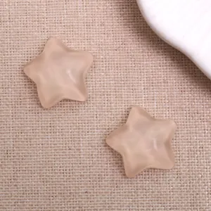 Gros plan détaillé de breloques étoiles en résine translucide pour vos loisirs créatifs.