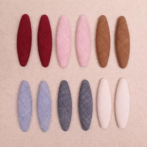 Fabric oval hair clips detail, DIY handmade patches in various colors, soft linen texture.