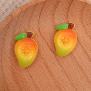 Vue détail des pendentifs mangue en résine, idéal pour coque de téléphone et accessoires DIY.