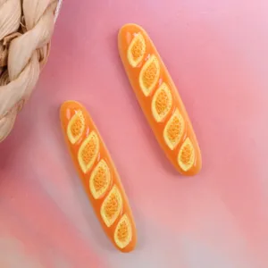 Resin baguette bread charm detail showing glossy texture and realistic baked miniature food look.