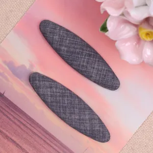 Grey fabric oval hair clip DIY patch, fabric texture close-up detail shot for handmade crafts.