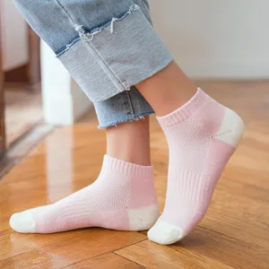Close-up detail of women pink mesh short socks with towel bottom on wooden floor background.