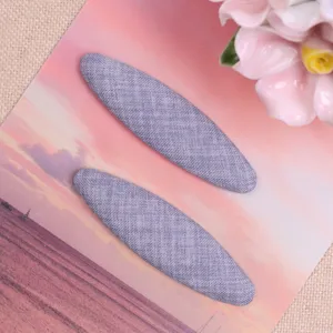 Fabric oval hair clip detail view, soft grey blue texture design for diy craft accessories.