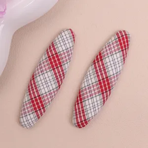 Close-up detail of red and white plaid oval fabric patch craft accessory for DIY decoration.