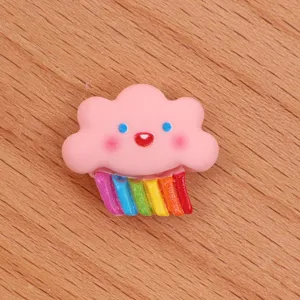 Close-up detail of cute pink cloud with colorful rainbow resin cabochon for DIY crafts.