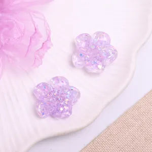 Close-up detail of purple glitter resin flower charms, perfect for DIY hair accessories.