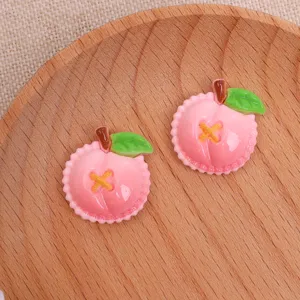 Gros plan de détails d'accessoires DIY en résine de pêche rose, tranche de fruit pour cheveux.