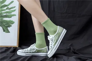 Fashion women's green mid-tube socks paired with trendy transparent canvas sneakers.