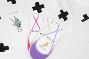 Dettagli di calzini invisibili con cinturino incrociato color caramella da donna.