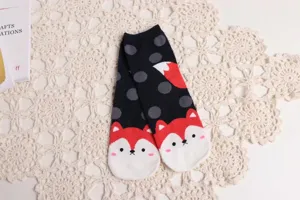 Vue détaillée de chaussettes en coton à motif de renard mignon avec des pois gris sur fond noir.