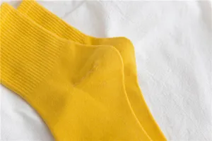 Yellow crew socks detail shot showing soft cotton fabric texture and neat stitching close-up.